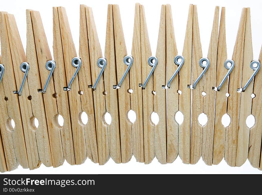 Eleven isolated wooden clothespins in a row. Eleven isolated wooden clothespins in a row