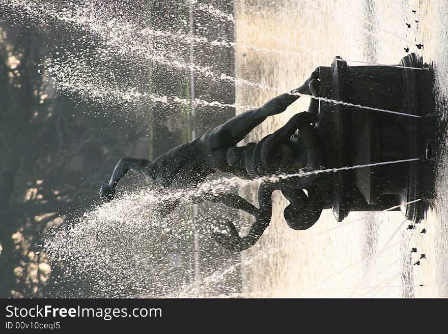 A golden pond with a fountain at sunset. A golden pond with a fountain at sunset