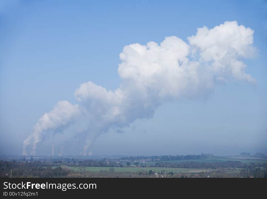 Power station bellowing emitting smoke from chimneys