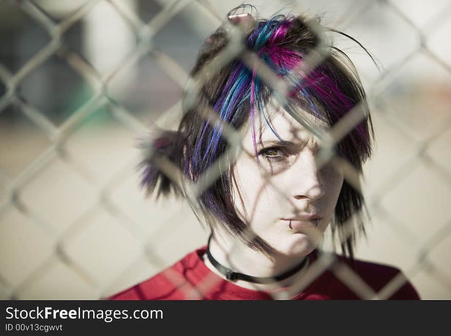 Young Punk Girl Being Shadowed By Chain Link. Young Punk Girl Being Shadowed By Chain Link