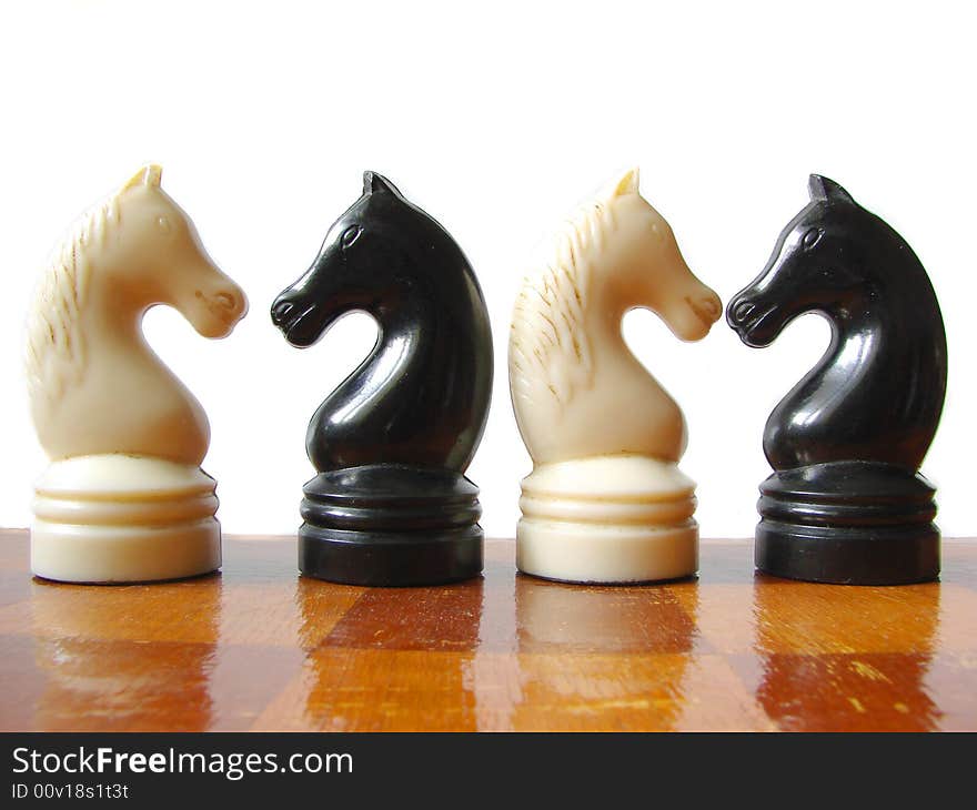 Black and white chess figures at checkerboard