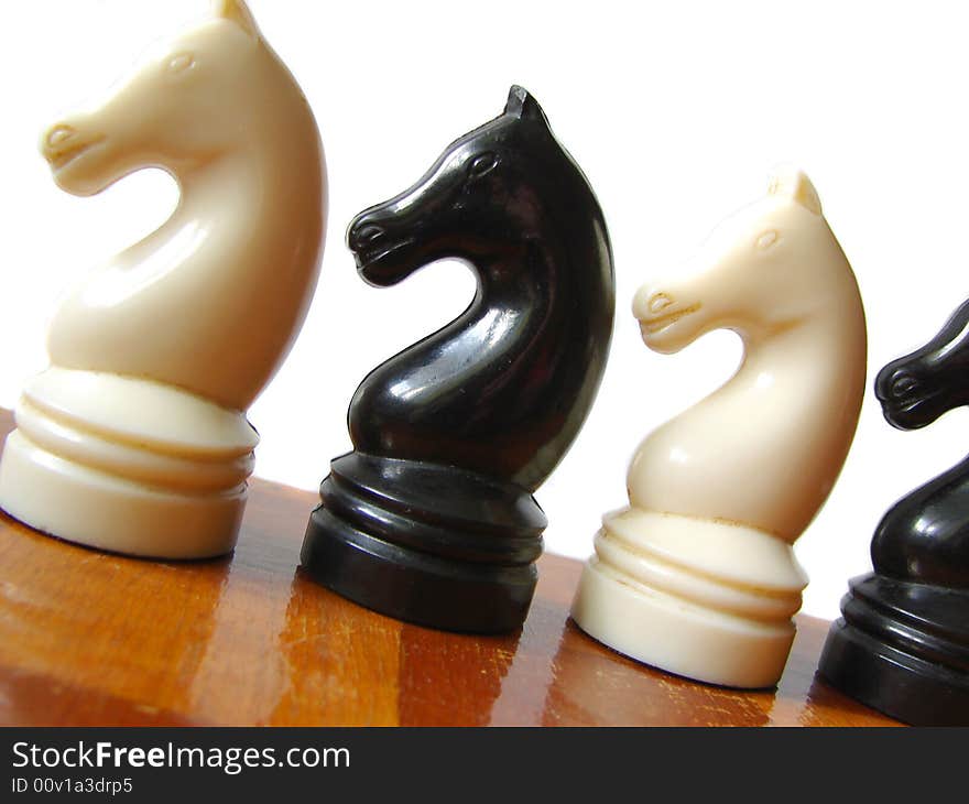 Black and white chess figures at checkerboard. Black and white chess figures at checkerboard