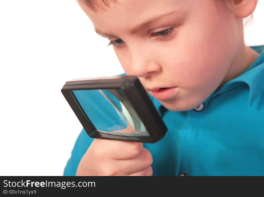 Boy looks through  magnifier on white