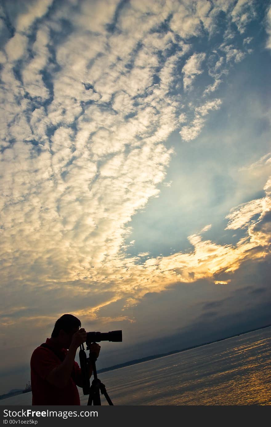 Sunrise with cloud formation with photographer sihouletted in the foreground. Sunrise with cloud formation with photographer sihouletted in the foreground.