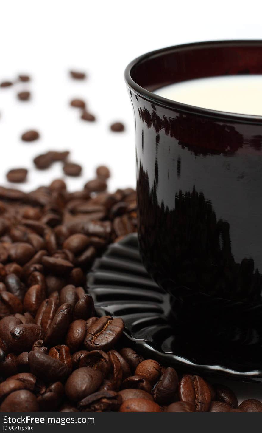 Coffee beans and milk in cup close-up. Coffee beans and milk in cup close-up