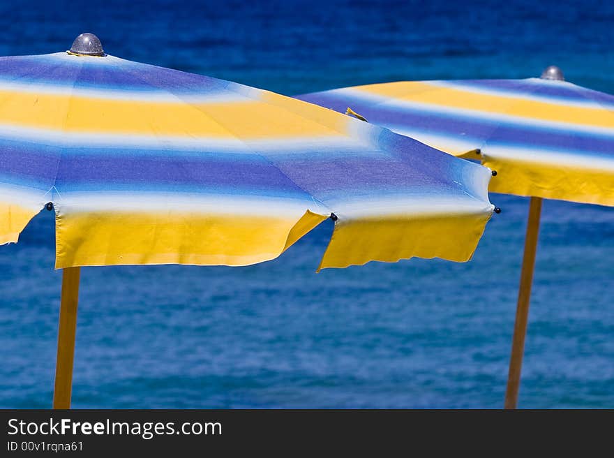 Umbrellas blue and yellow and water