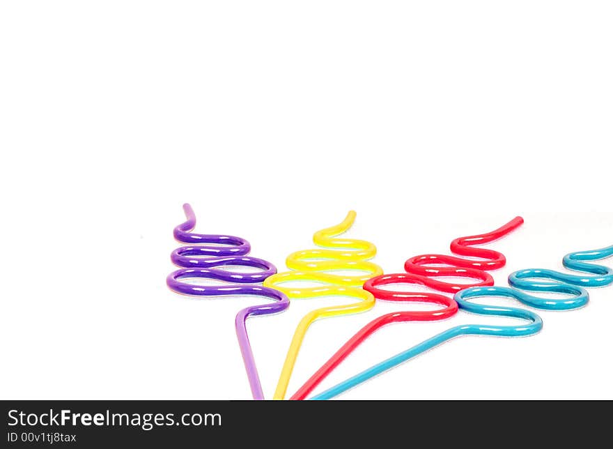 Party Straws with Copy Space is a capture of purple, yellow, red and blue curvy party straws isolated over a white background.