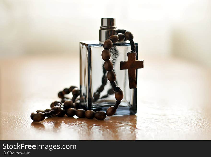 A view with a bottle of perfume and rosary. A view with a bottle of perfume and rosary