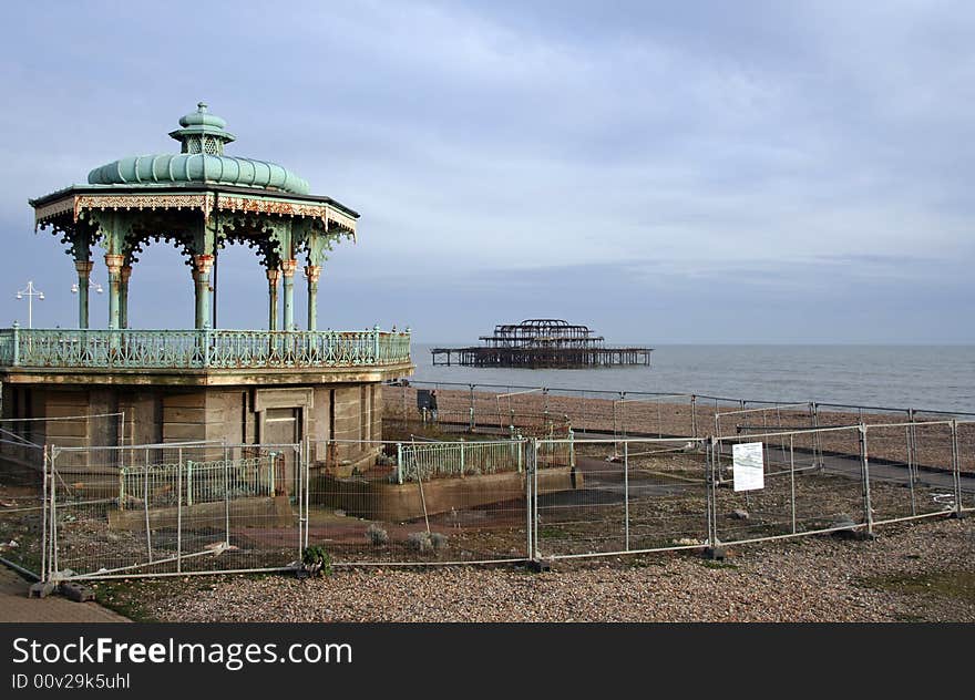 Old decaying Victorian bandstand on the Brighton and Hove promenade with the burnt down West Pier in the background