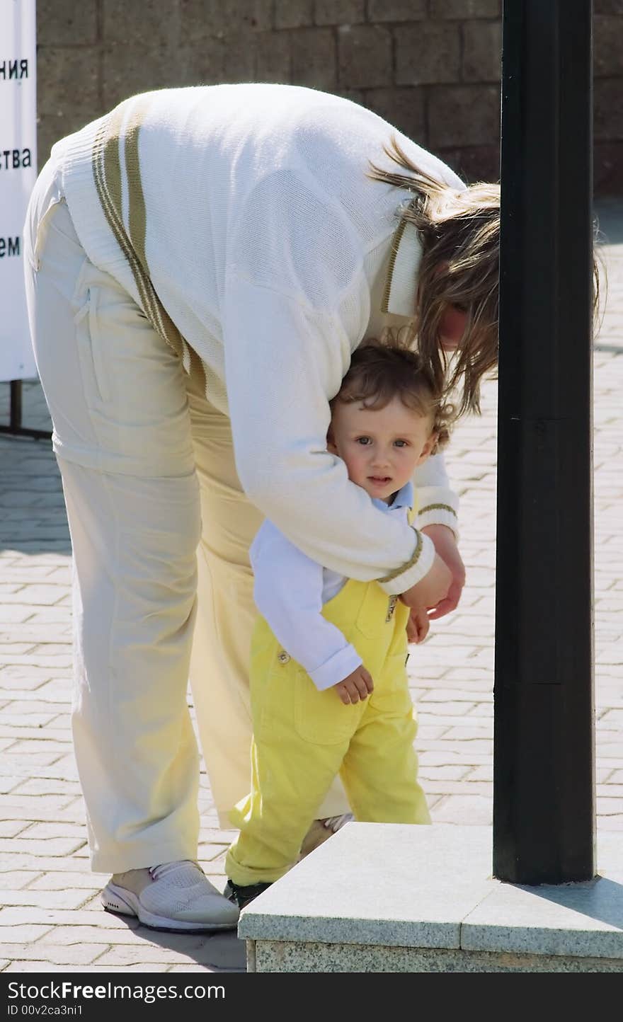 The young woman with the curly boy on hands on a background of the big city