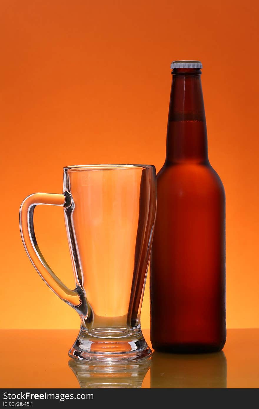 Empty mug and bottle of beer over orange background. Empty mug and bottle of beer over orange background