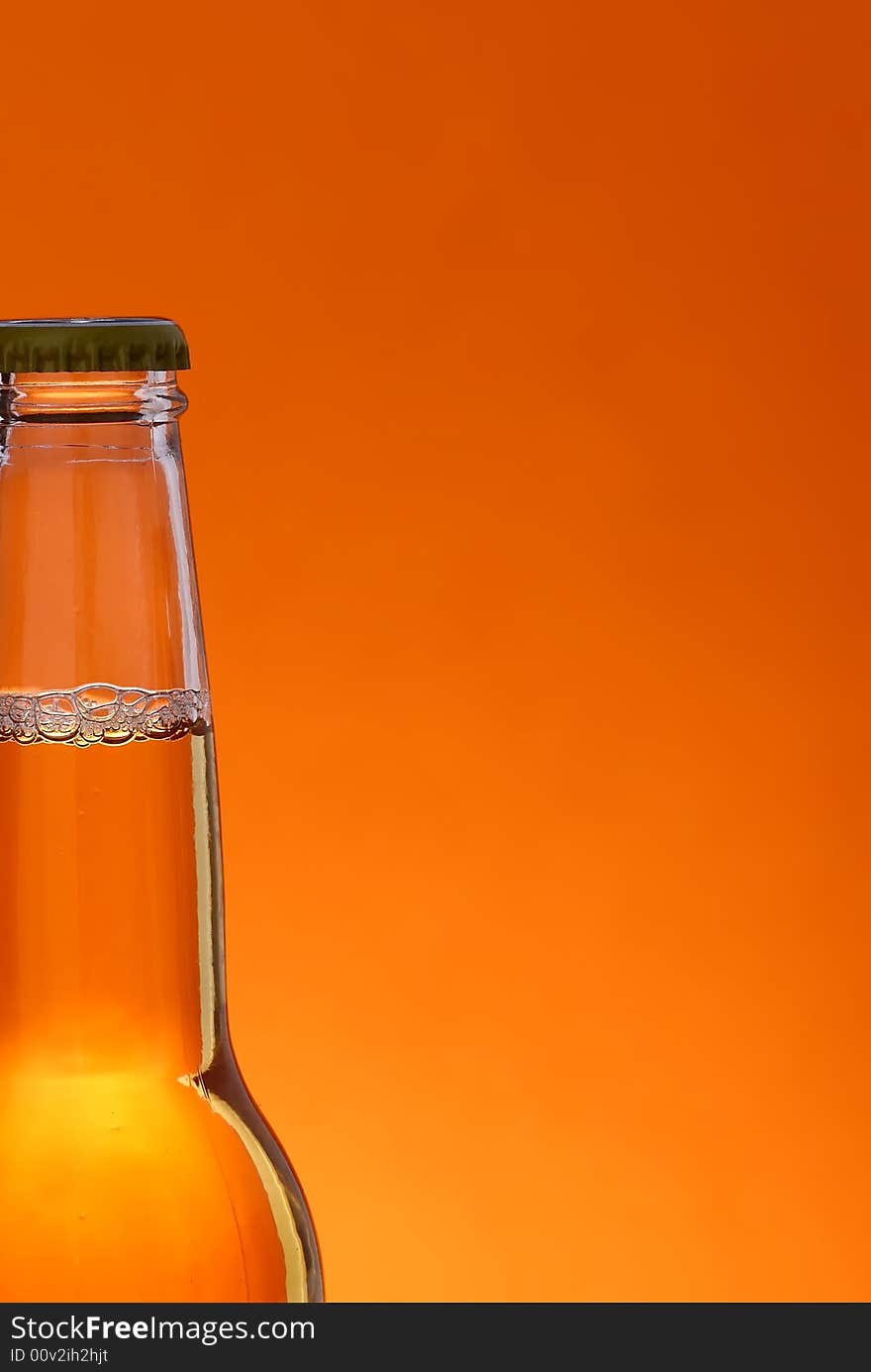 Close up of beer bottle over orange background