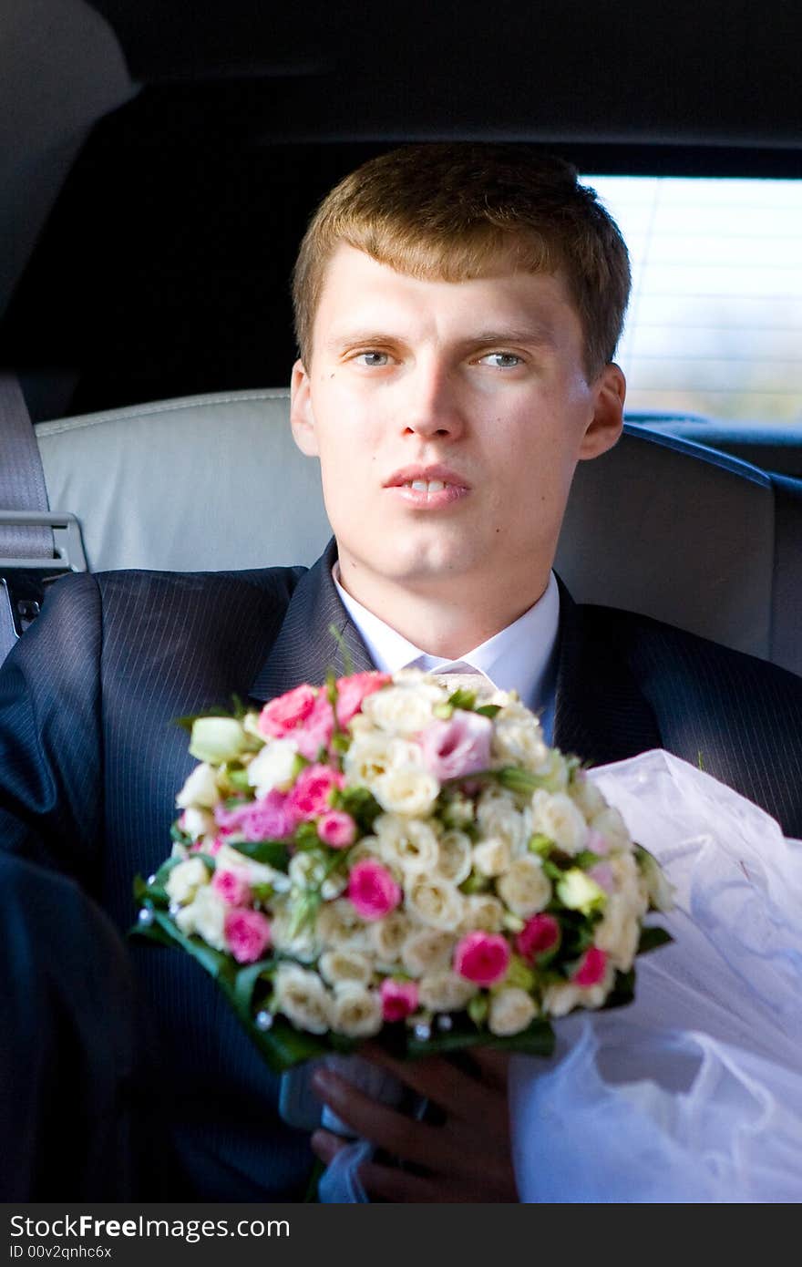 Groom with flower bouquet in the car. Groom with flower bouquet in the car