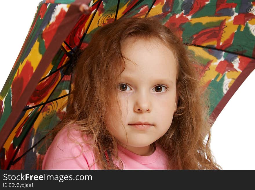 The little girl sits under an umbrella. The little girl sits under an umbrella