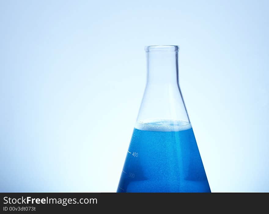 Erlenmeyer flask filled with blue liquid blue tint with copyspace