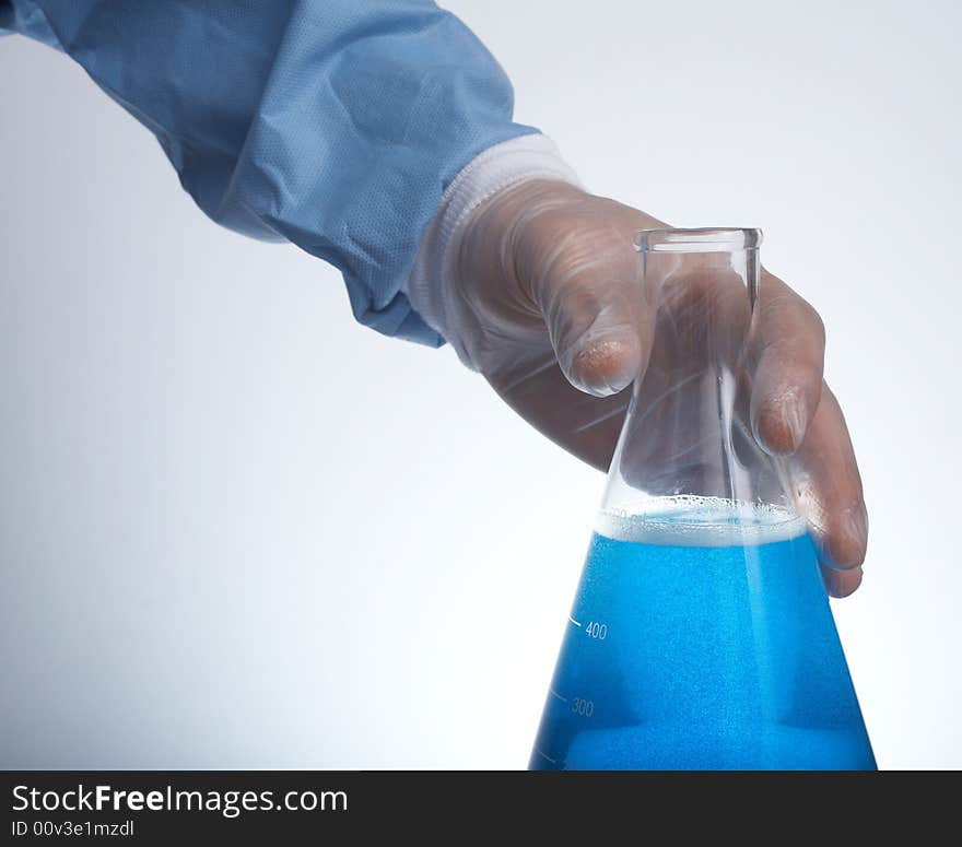 Hand holding erlenmeyer flask with blue liquid