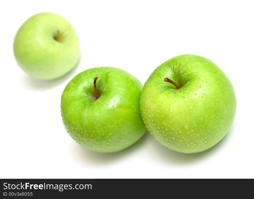 The ripe juicy apples covered by drops of water. Isolation on white, shallow DOF.