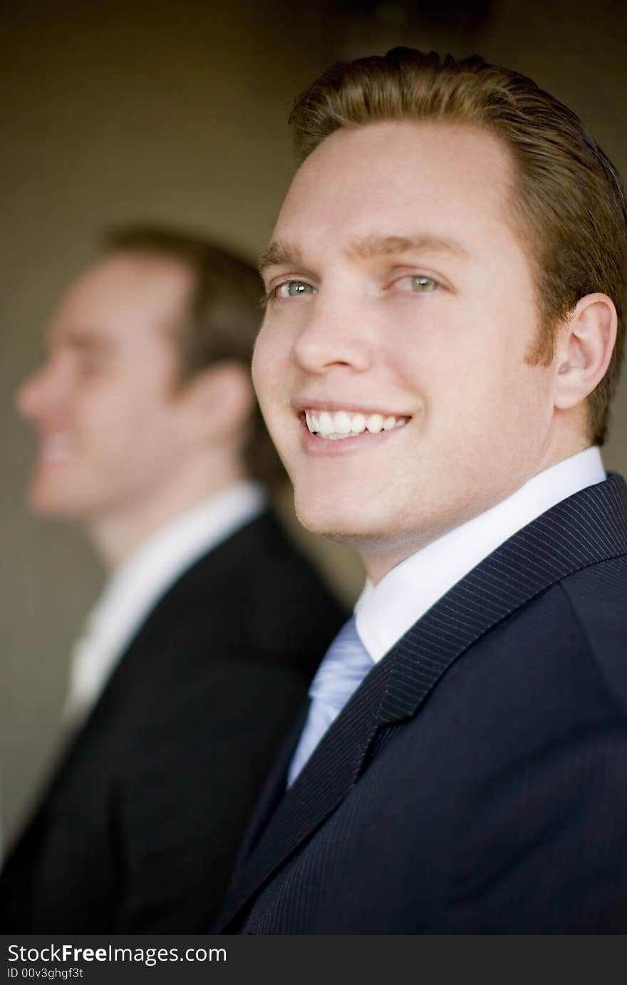 Side view of two businessmen in suits smiling