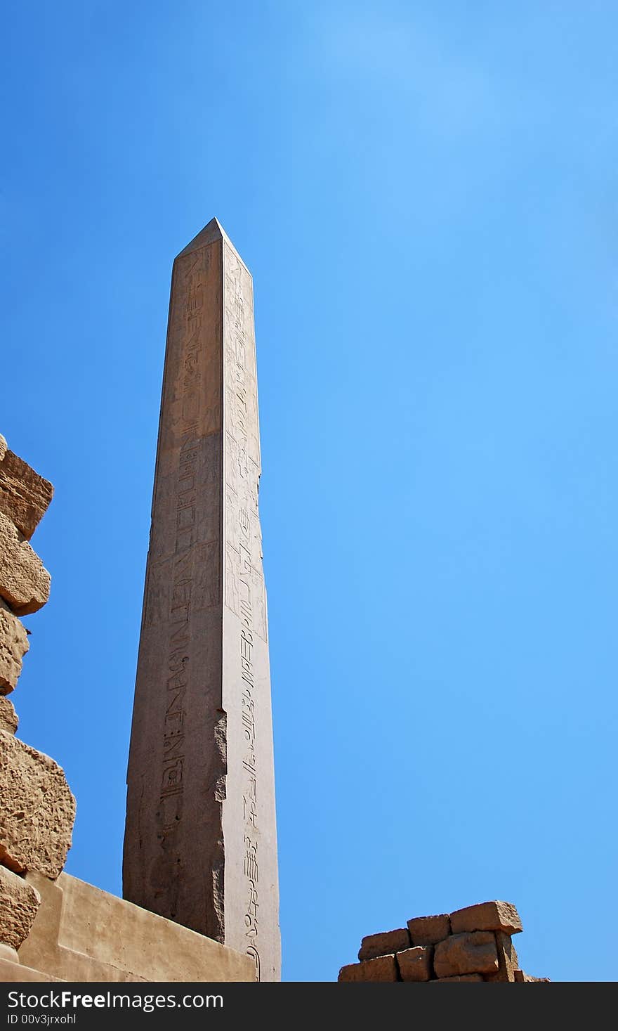 Egyptian obelisk with hieroglyphs on the blue sky