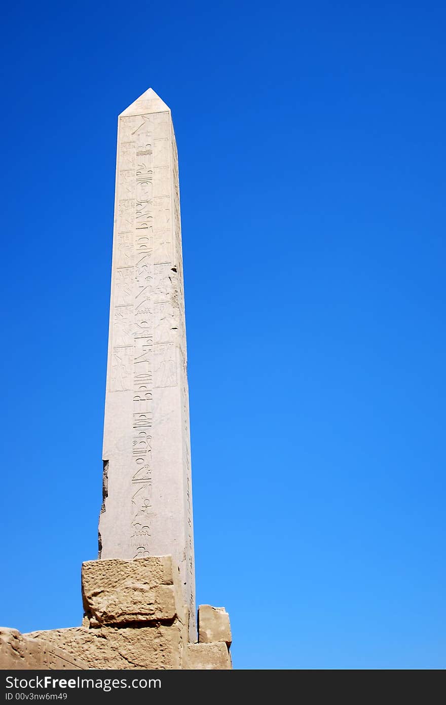 Egyptian obelisk with hieroglyphs on the blue sky