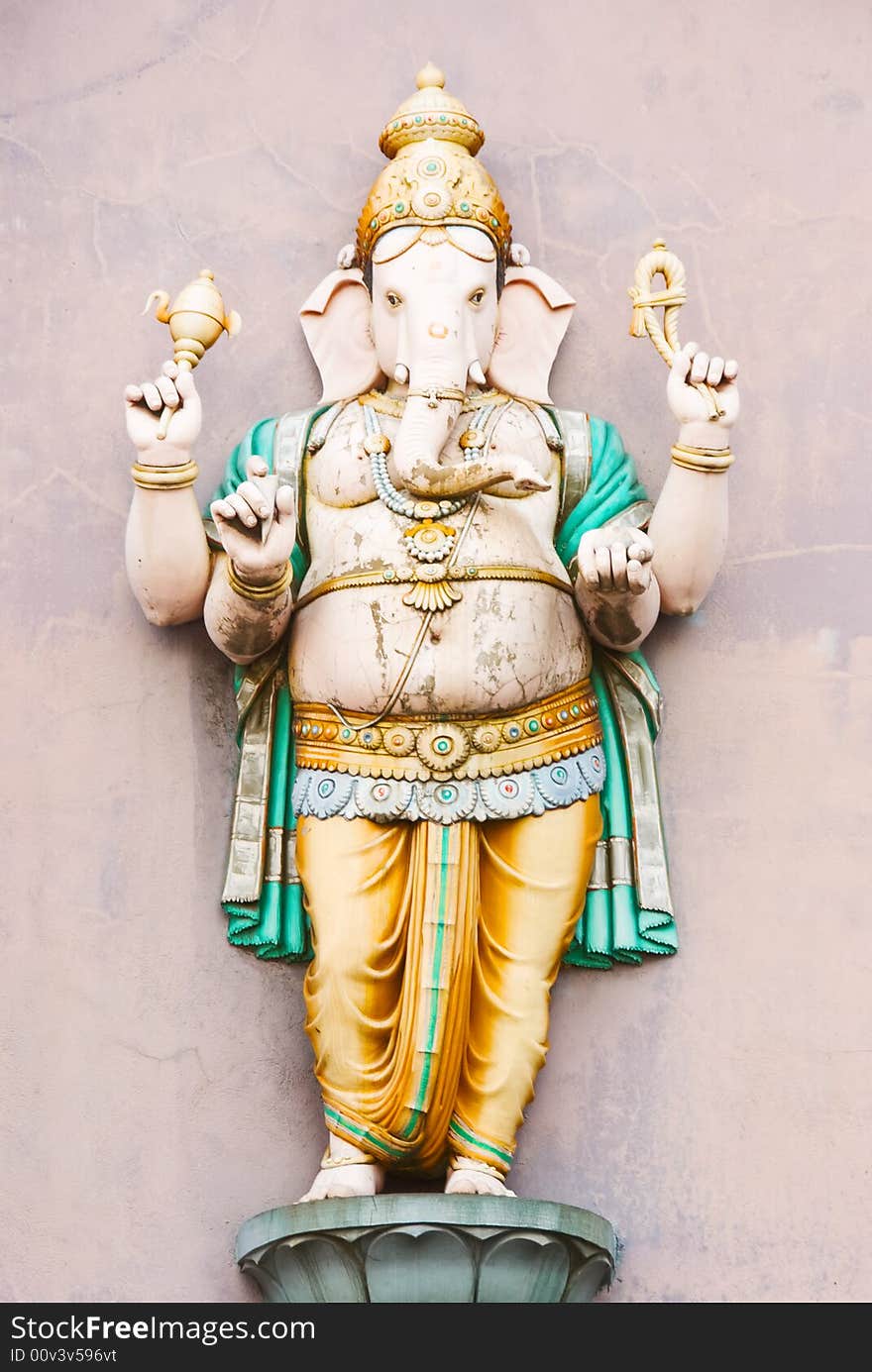 Hindu deity statue against a pale wall