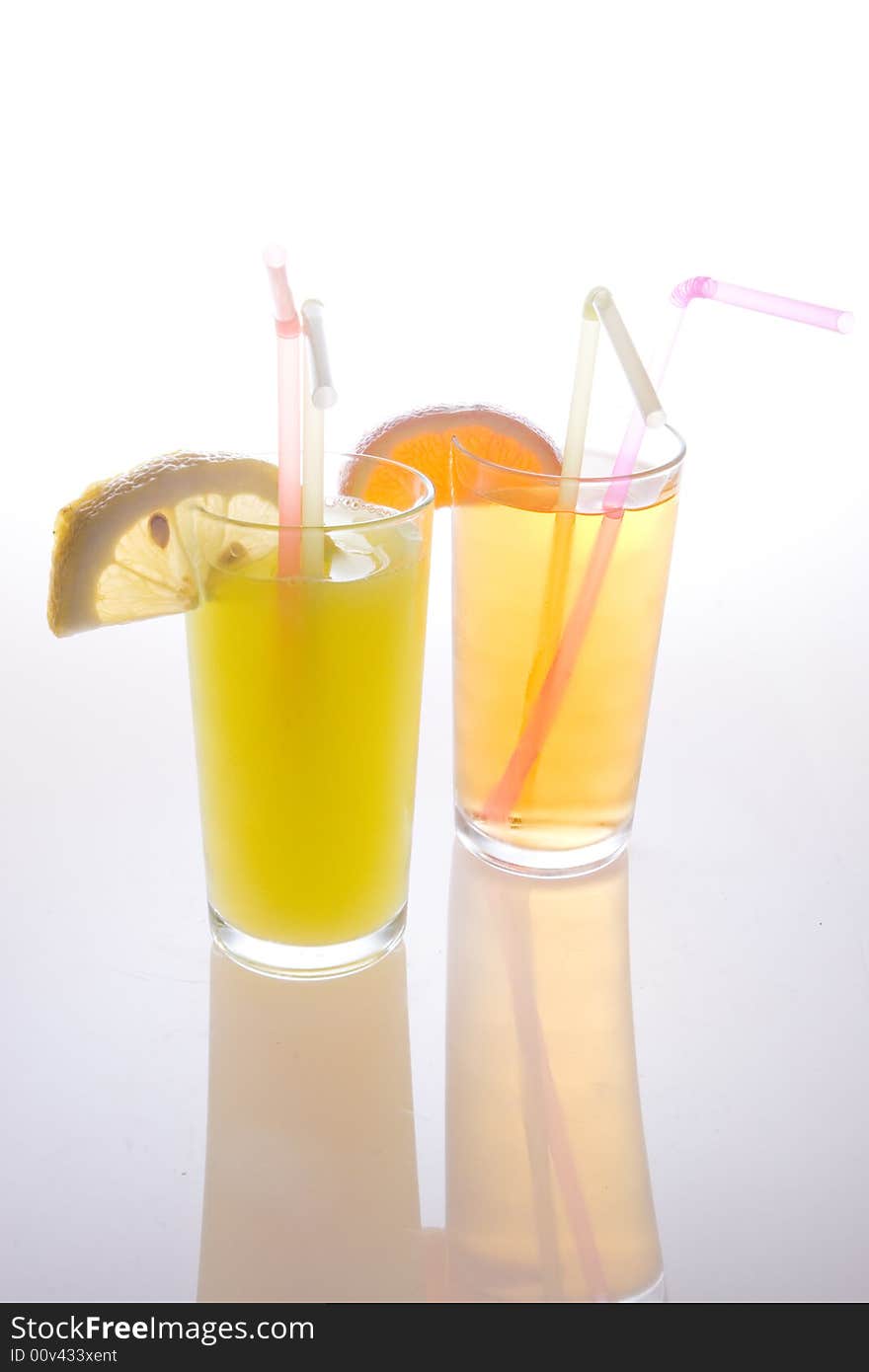 Fruit juice in glasses with straws