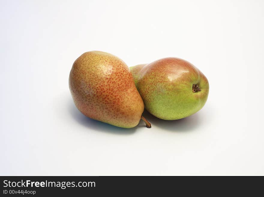 Two ripe red and green pears lying on white background. Two ripe red and green pears lying on white background