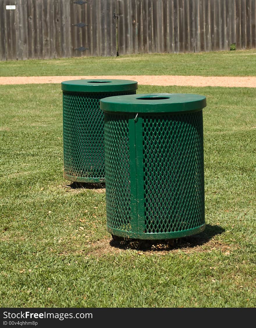 Dark green trash bins outdoors on grass. Dark green trash bins outdoors on grass.