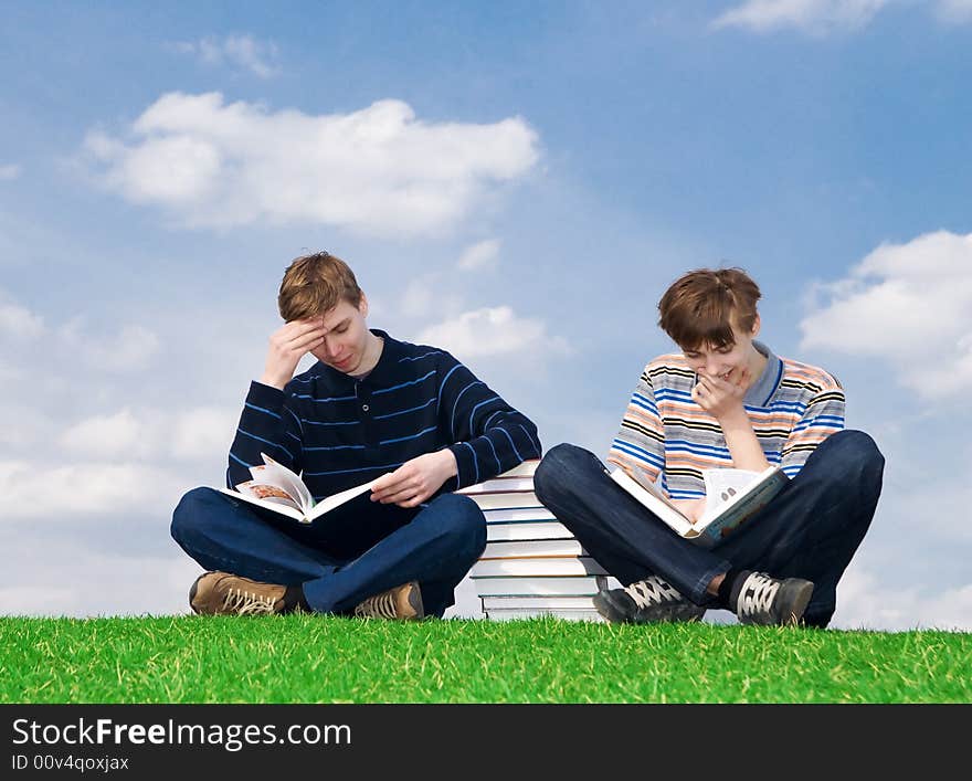 The two students with the book on a background of the blue sky