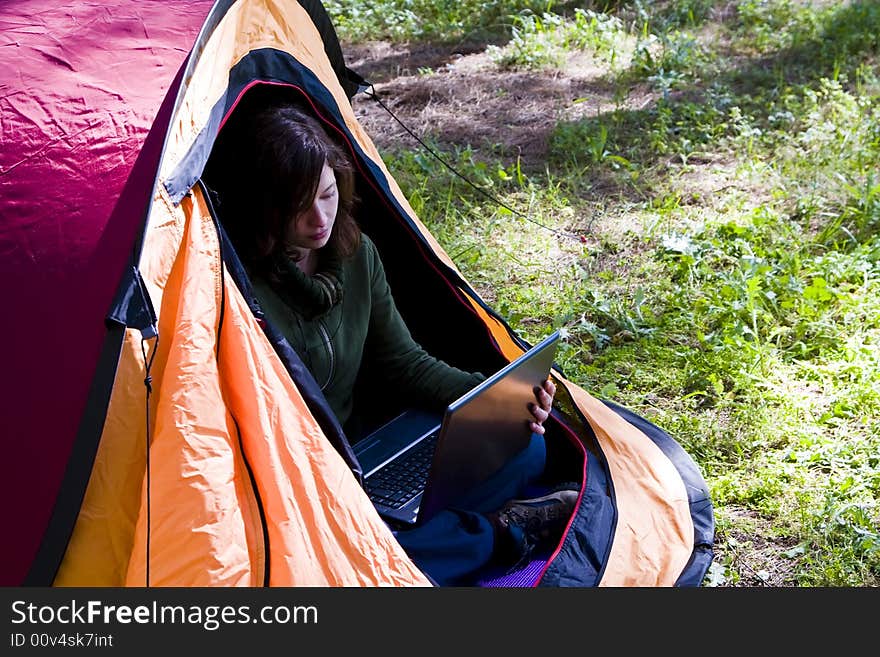 Young woman using laptop in the middle of the forest. Young woman using laptop in the middle of the forest