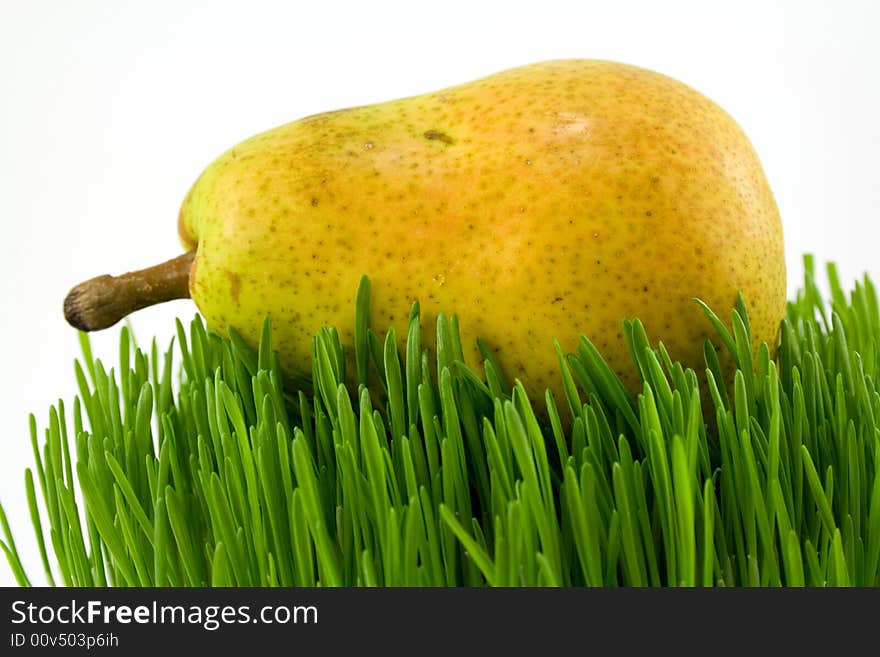 Yellow pear on grass isolated on white