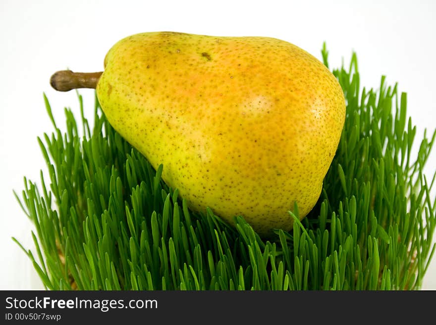 Pear on grass isolated on white