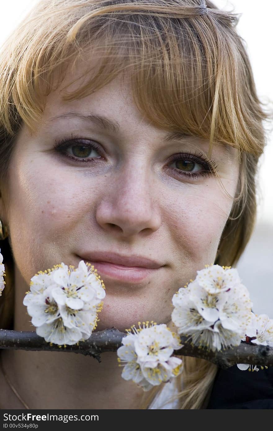 Fashion portrait of a beautiful blonde girl with flowers of apricot