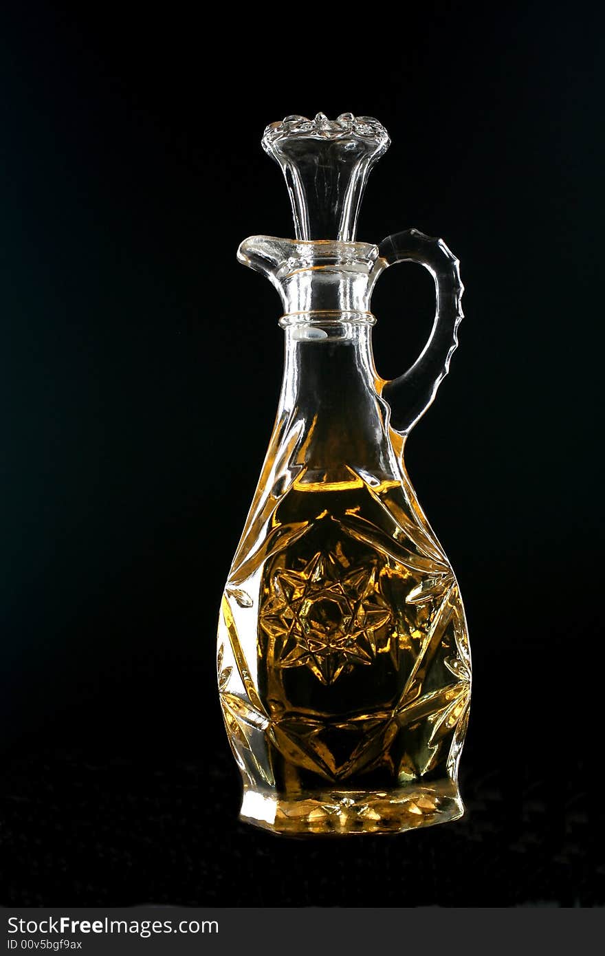 Olive oil bottle on black background.