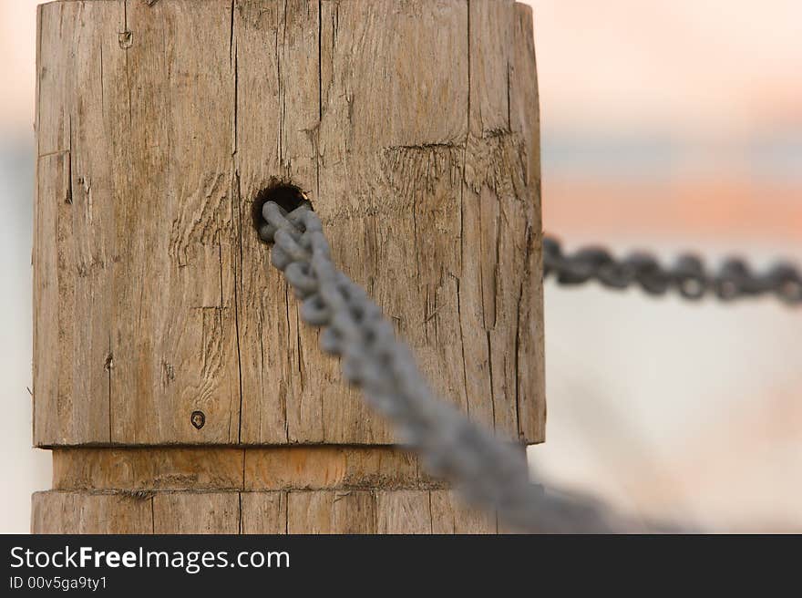 Chain link through a hole in a post. Narrow depth of focus. Chain link through a hole in a post. Narrow depth of focus.