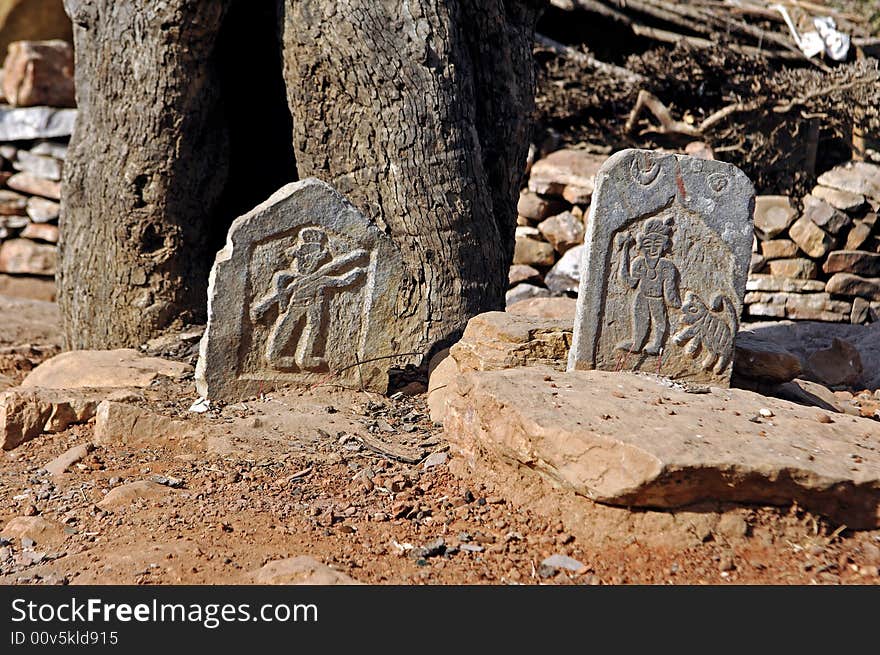 India, Chittorgarh: Tombs near Chittorgarh; red sand and small carved stones with figures