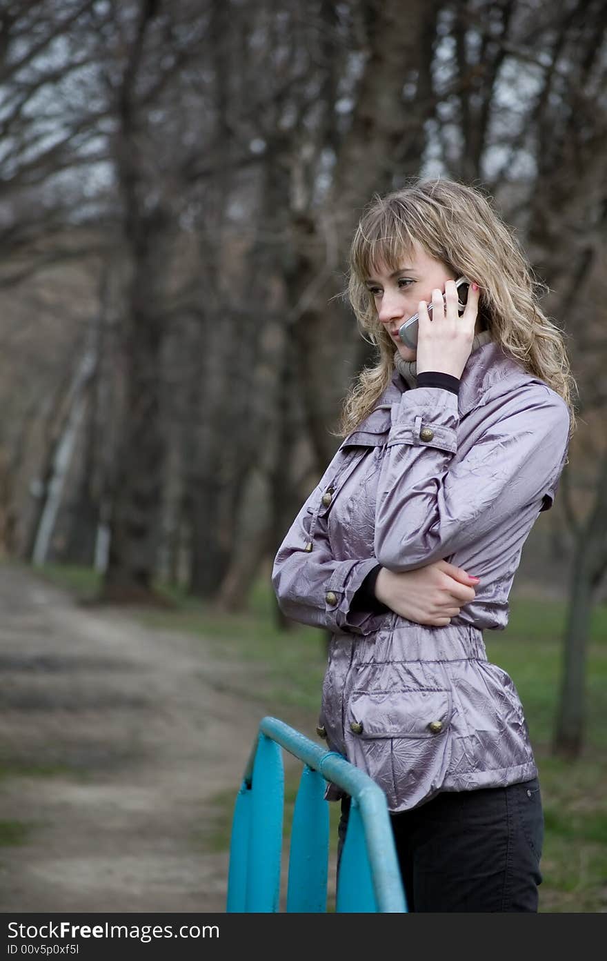 Girl speaks by phone in park. Girl speaks by phone in park