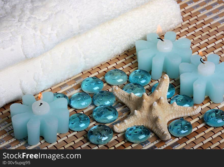 Bath towels, candles, starfish and glass pebbles. Bath towels, candles, starfish and glass pebbles