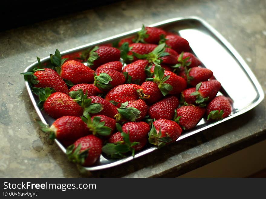 A lot of fresh strawberries on silver plate