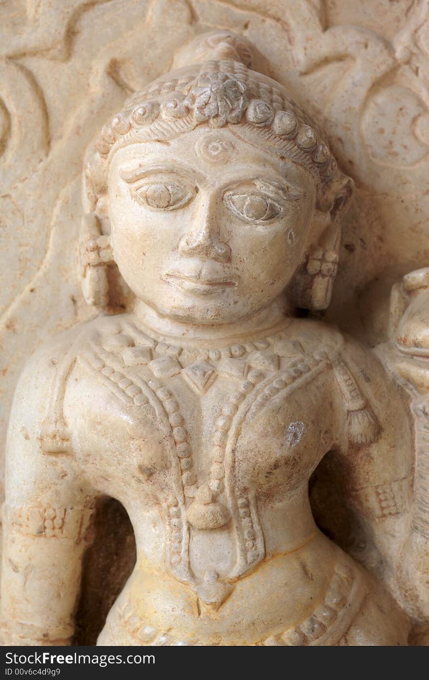 India Jaipur sculpture in an hindu temple; representation of a woman; maybe a deva; round face and voluptuous shapes