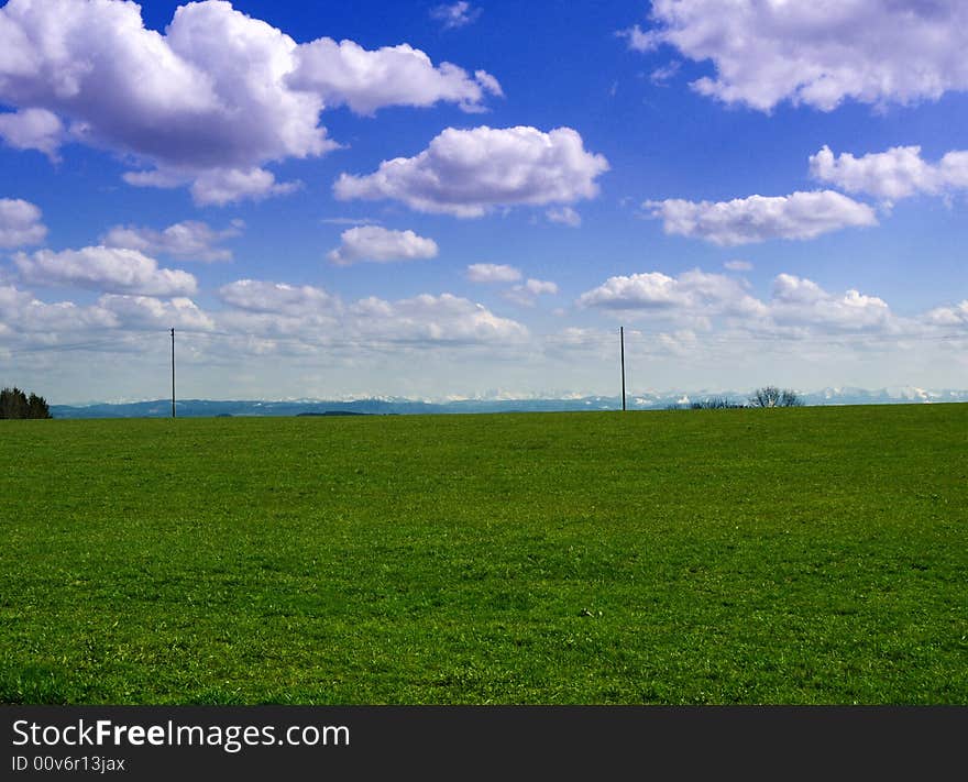 Green grasland with sky and clouds