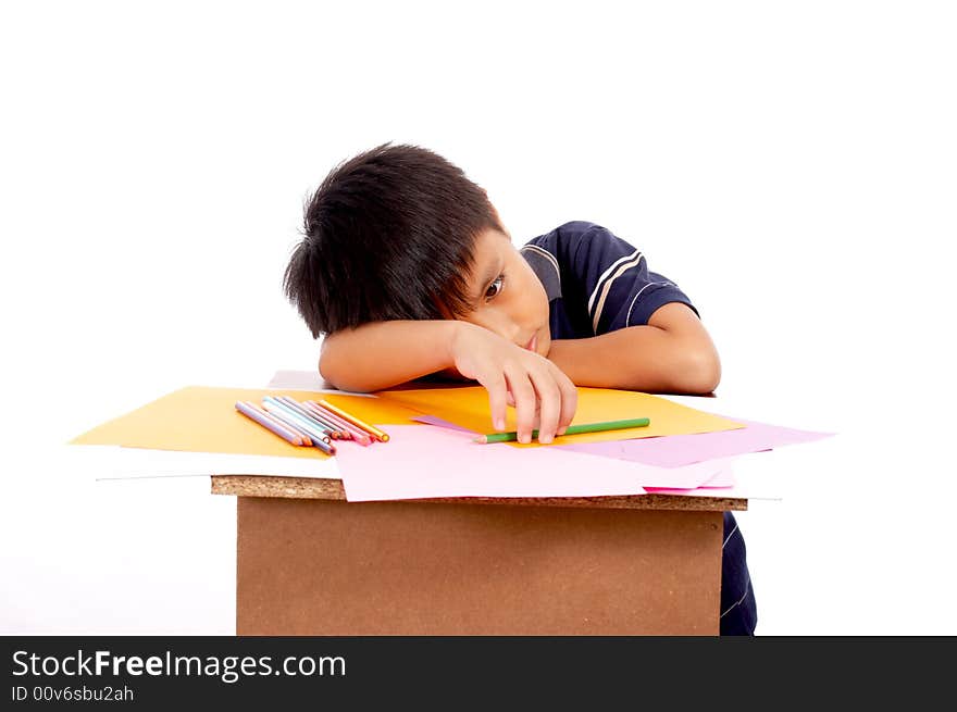 Young man lying on desk holding colored pencil