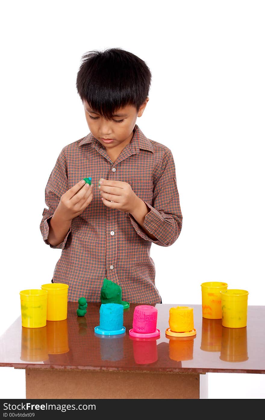 Young man seriously playing colorful clay dough