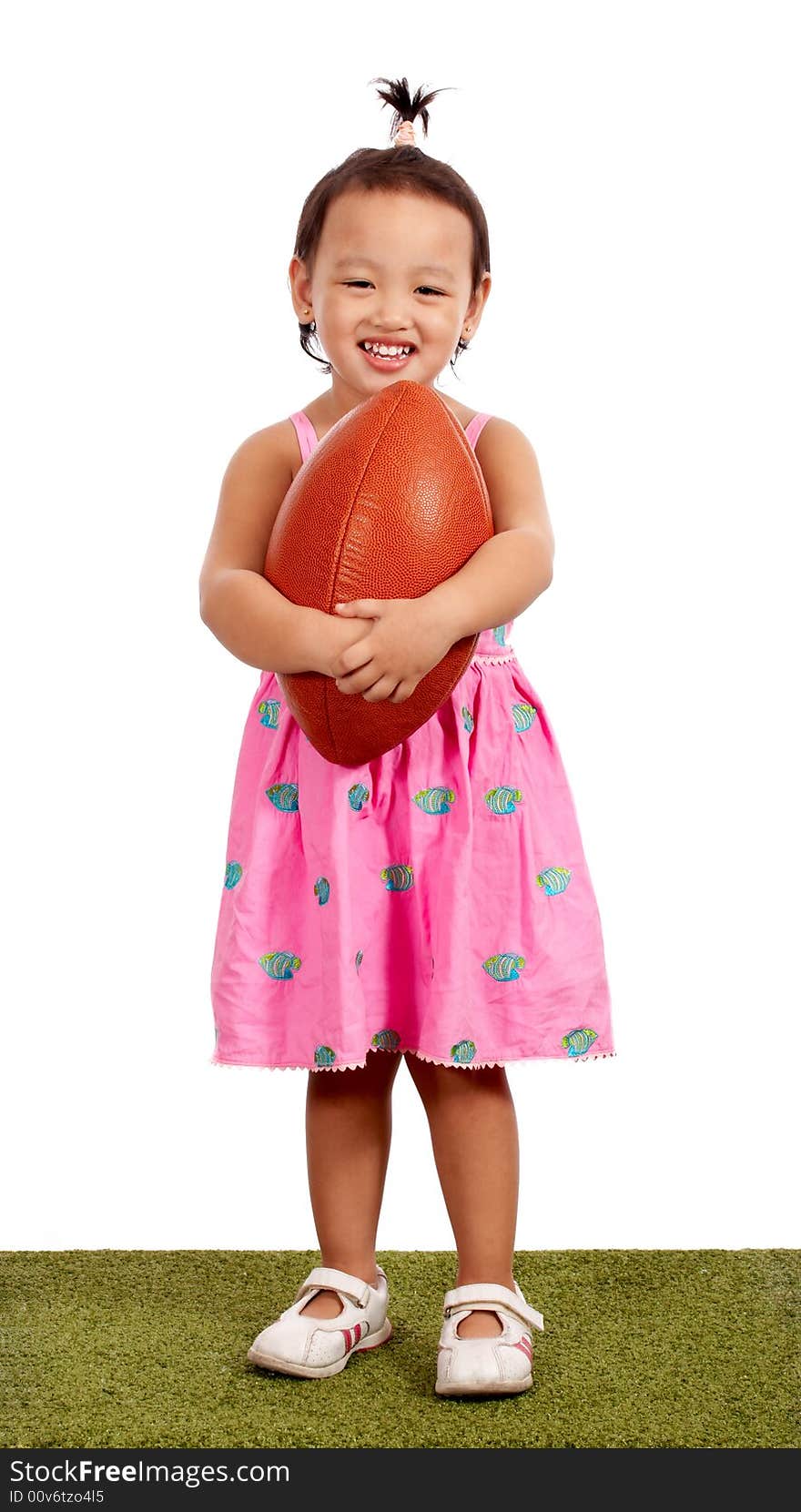 Young little girl holding a rugby ball