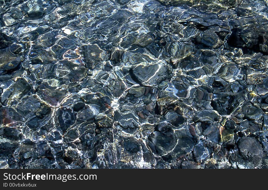 Sun reflections on stones in water