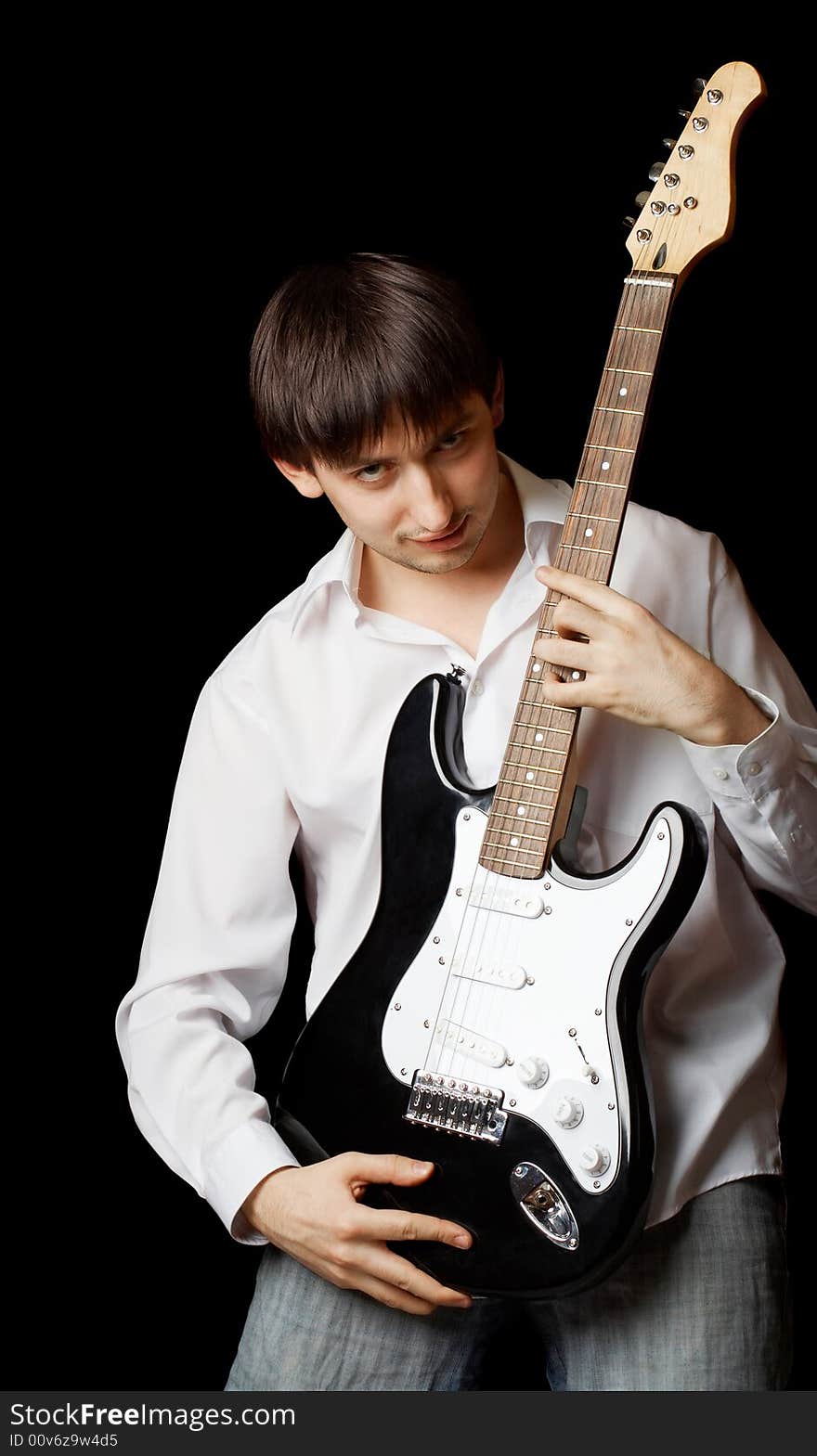 Young man with guitar isolated on black