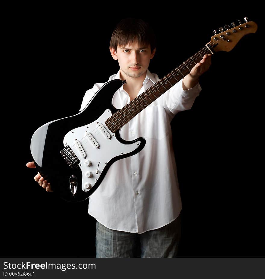 Young man with guitar isolated on black