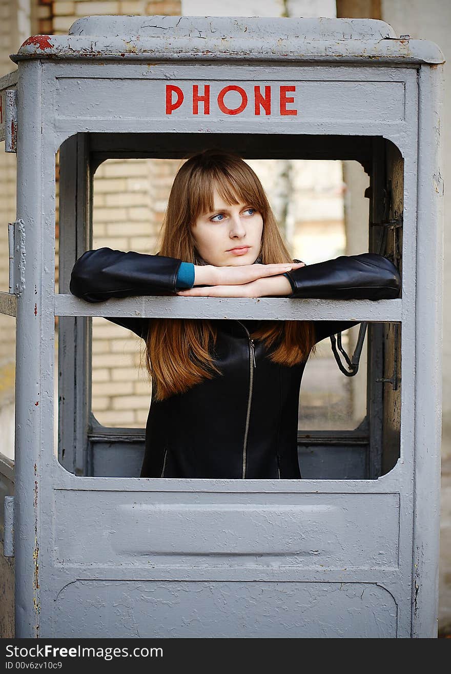 Lonely girl waiting ring in old phonebox. Lonely girl waiting ring in old phonebox