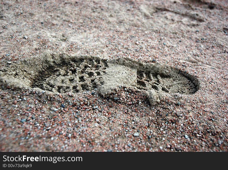 Foot print of boots in mud and sand