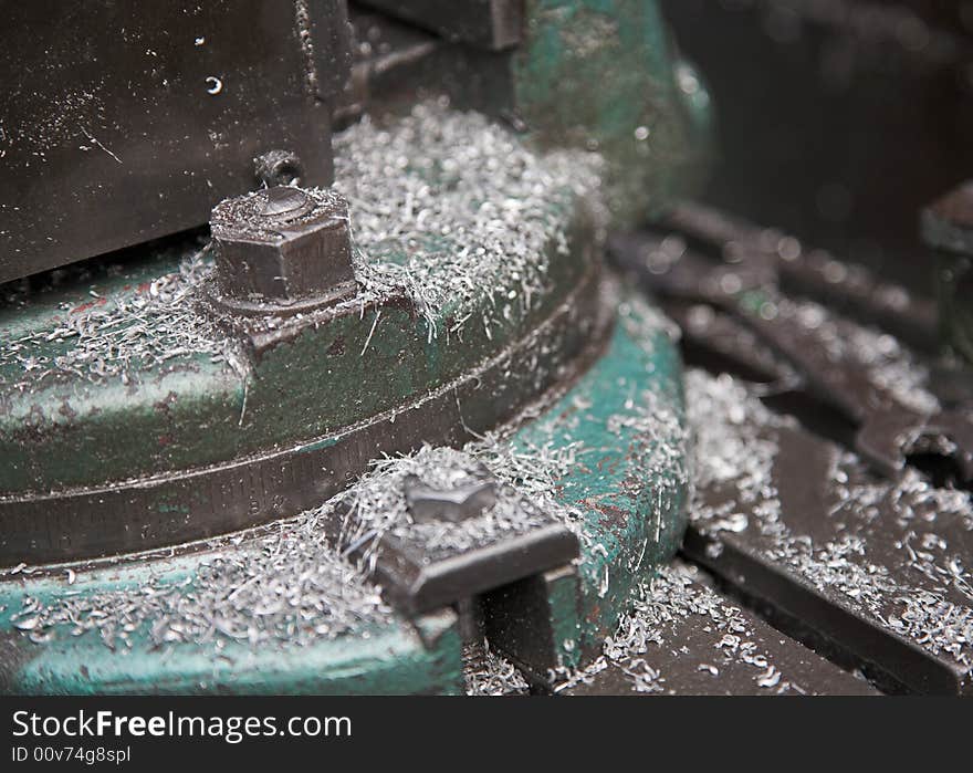 Drill support in an engineering workshop, with metal shavings. Drill support in an engineering workshop, with metal shavings.